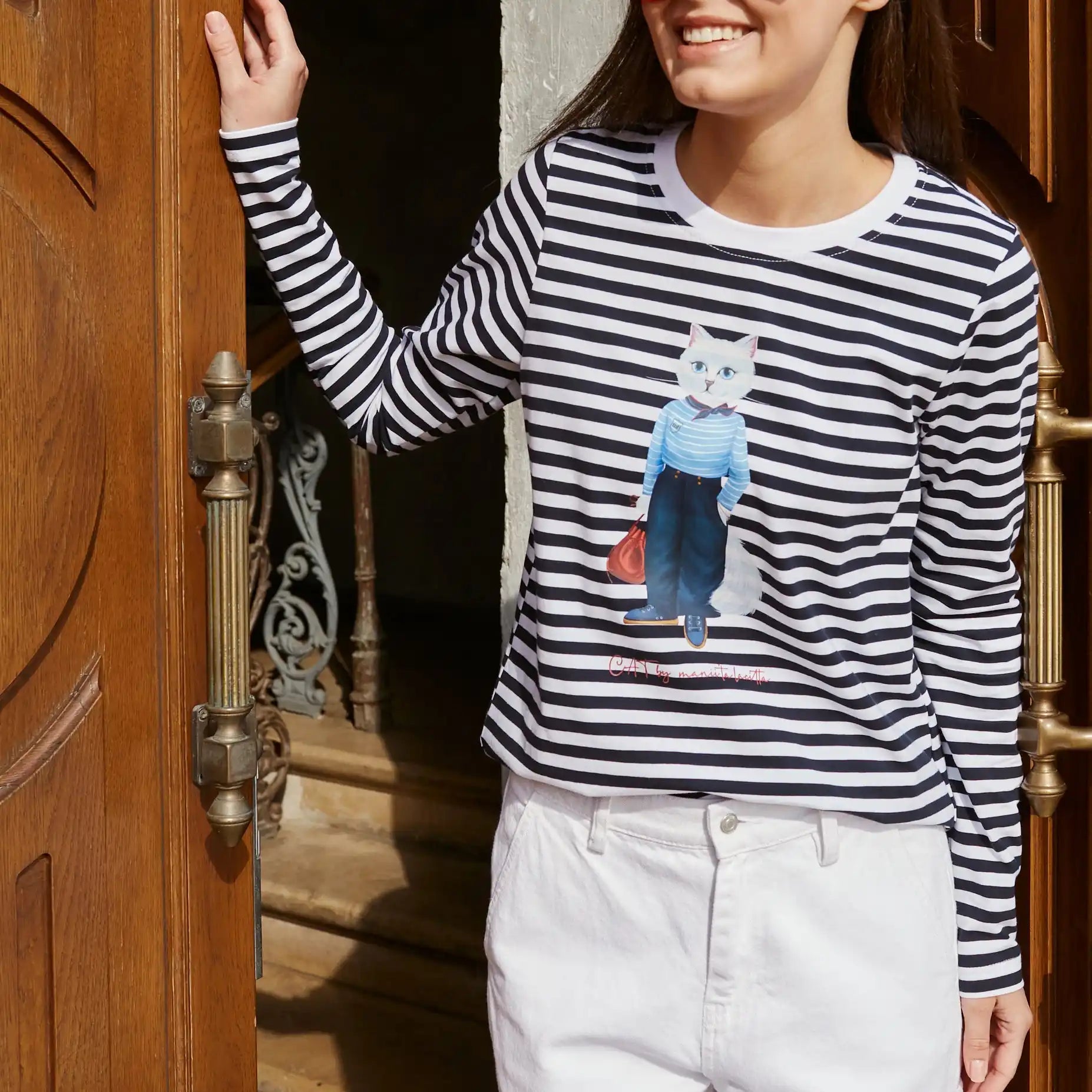 Striped long-sleeve shirt with cat graphic.