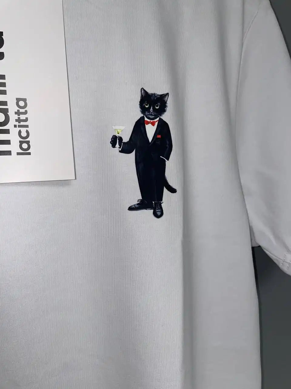 White t-shirt with tuxedo cat graphic.
